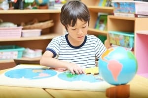 Little boy completing the globe puzzle