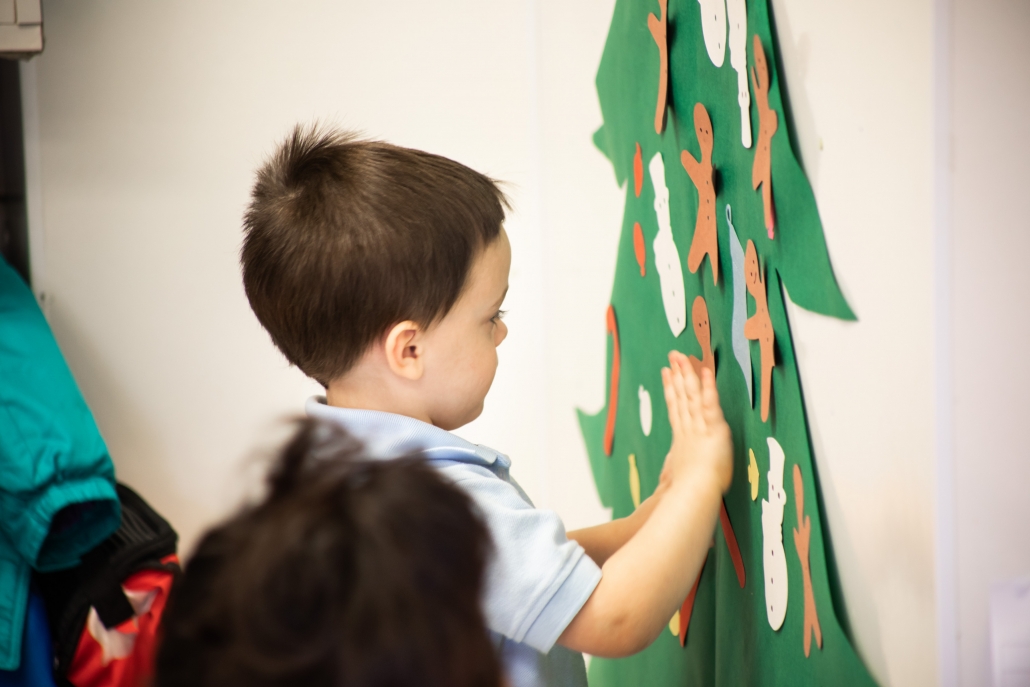 Little Boy pasting Human Paper to Christmas tree